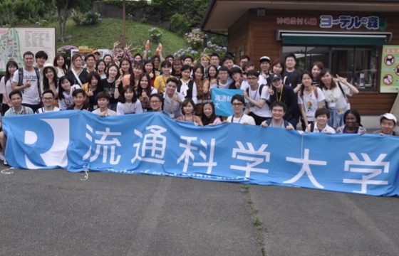 ヨーデルの森入口の前に数十人の大学生が並んでいる集合写真